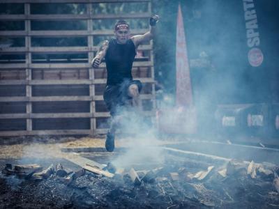 Atleta salta sopra il fuoco durante una gara di resistenza.