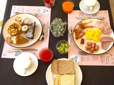 Colazione con dolci, salumi, uova e bevande.