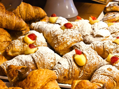 Croissant con crema e fragole, decorati con zucchero a velo.