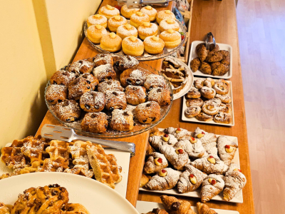 Varietà di dolci su un tavolo di legno, ricoperti di zucchero a velo.