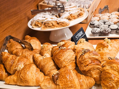 Deliziosi croissant, strudel e muffin su un tavolo da colazione.