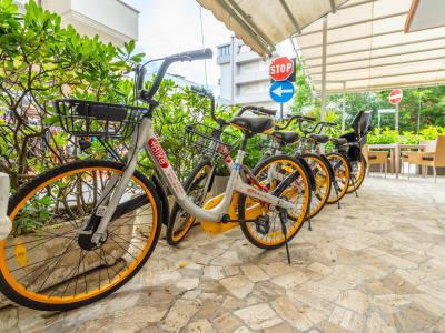Biciclette condivise parcheggiate vicino a segnali stradali in una zona urbana.