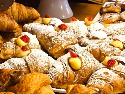 Croissant ripieni di crema, decorati con fragole e zucchero a velo.