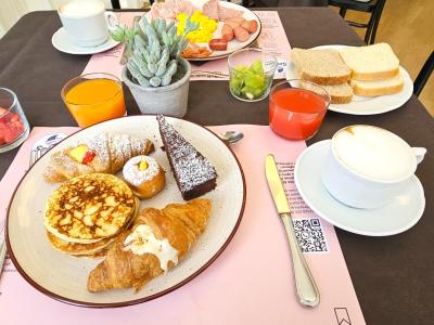 Colazione ricca con dolci, frutta e bevande.