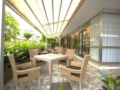 Terrazza con sedie in vimini sotto una tenda.
