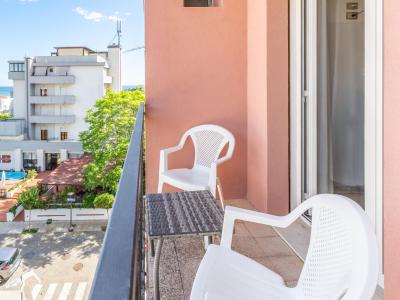 Balcone con sedie bianche e vista mare.
