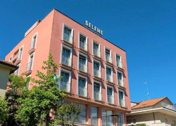 Edificio rosa a più piani con insegna Selene e cielo blu.