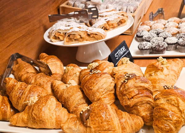 Deliziosi croissant, strudel e muffin su un tavolo da colazione.