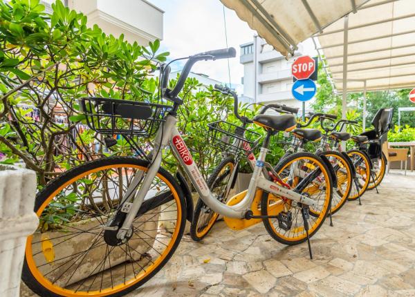 Biciclette condivise parcheggiate vicino a segnali stradali in una zona urbana.