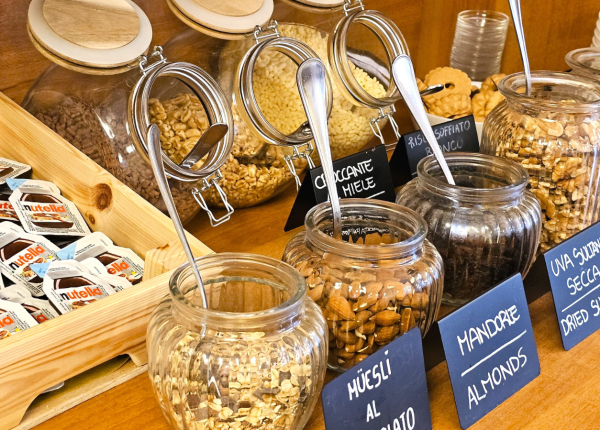 Dispensa con cereali, mandorle e Nutella in vasetti.