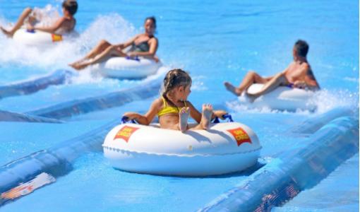 Persone su ciambelle galleggianti si divertono in un parco acquatico.