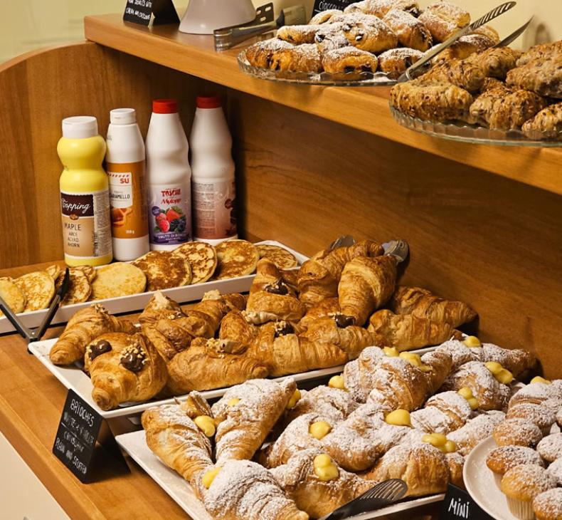 Croissant e strudel su un tavolo da buffet, pronti per essere serviti.