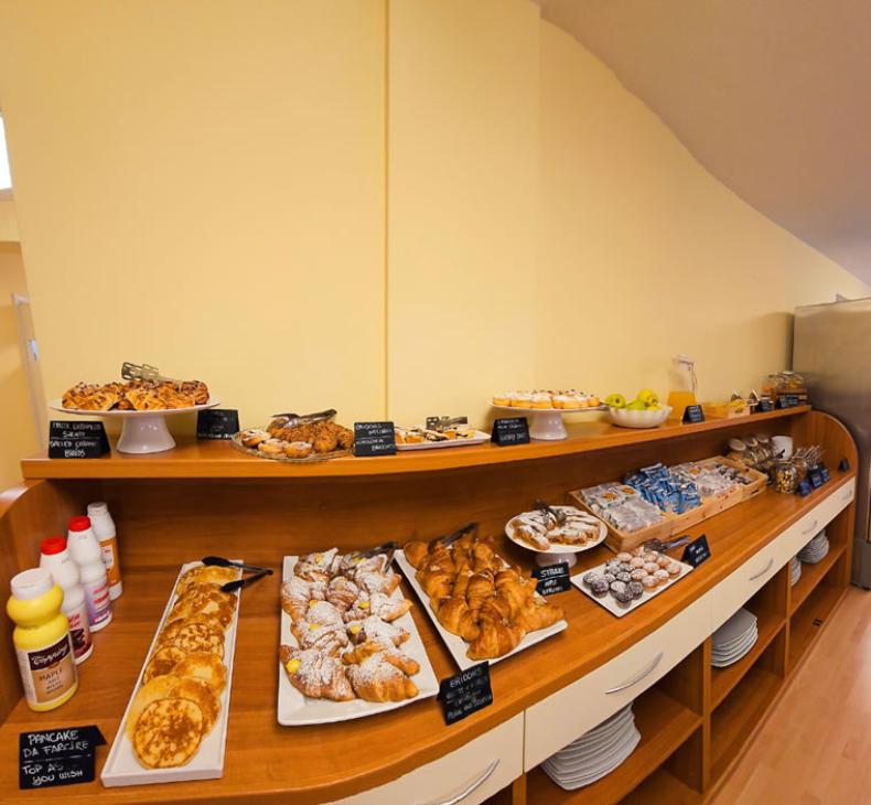 Barattoli di cereali, mandorle e muesli con etichette e cucchiai in un buffet.