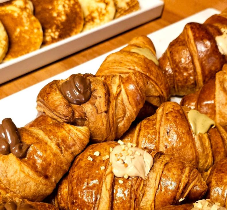 Croissant con crema al cioccolato e nocciole, accompagnati da pancake soffici.