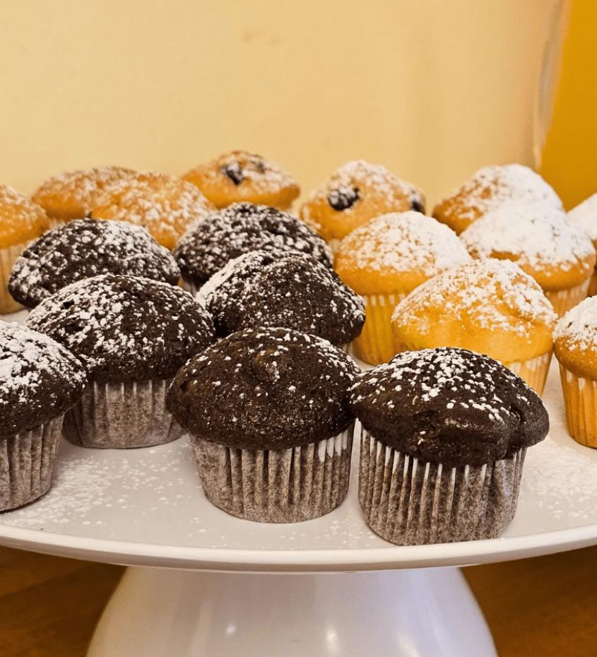 Vassoio di muffin al cioccolato e vaniglia spolverati di zucchero a velo.