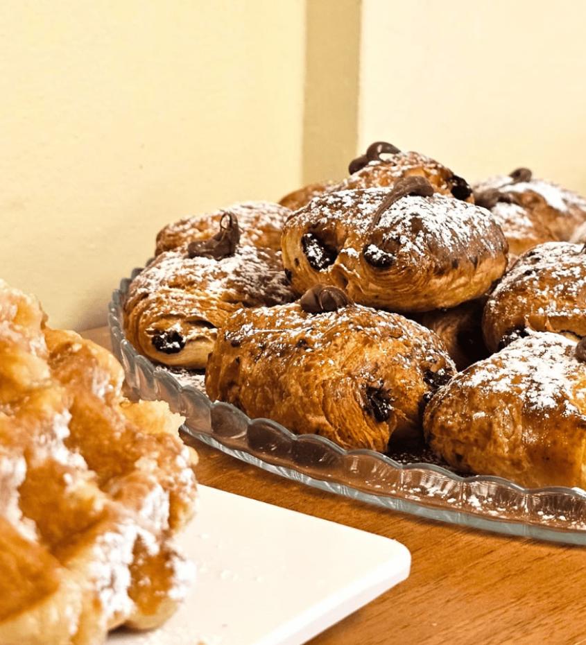 Dolci al cioccolato e waffle spolverati di zucchero a velo su un tavolo.