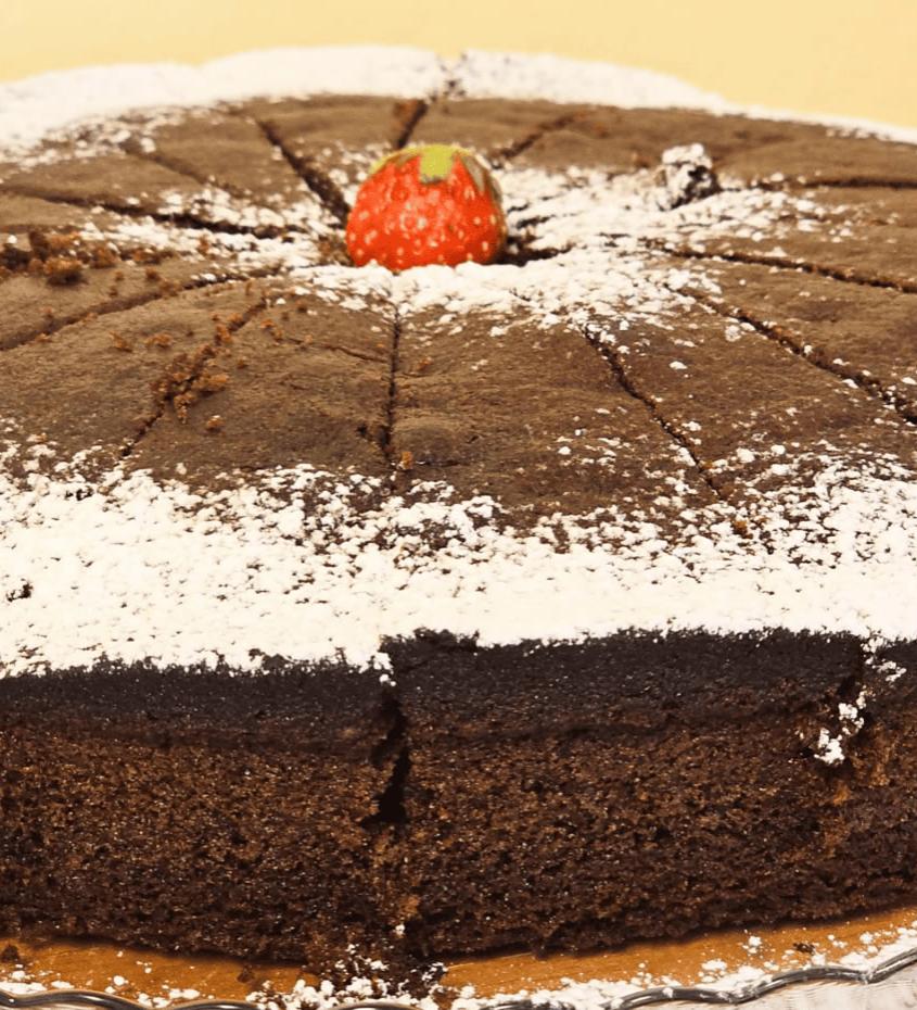Torta al cioccolato con zucchero a velo e fragola al centro.