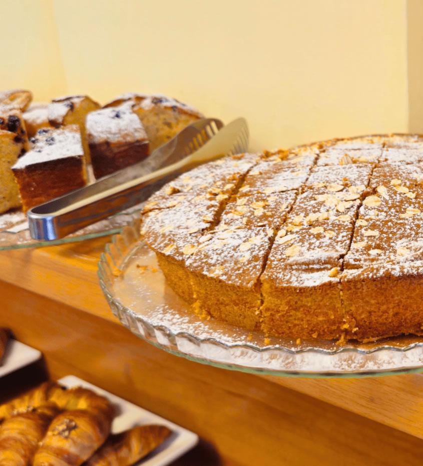Dolci assortiti su piatti di vetro, spolverati con zucchero a velo.