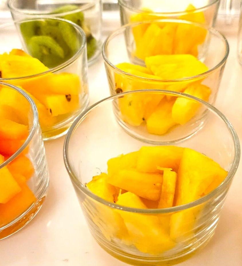 Bicchieri con frutta fresca: kiwi, ananas e papaya a cubetti.